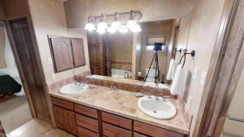 a bathroom with two sinks and a large mirror at River Ritz - Pet Friendly - WiFi - Near the Ski Area - Fireplace - On the River - Washer - Dryer - in Red River