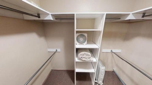a walk in closet with white shelves and a fan at River Ritz - Pet Friendly - WiFi - Near the Ski Area - Fireplace - On the River - Washer - Dryer - in Red River