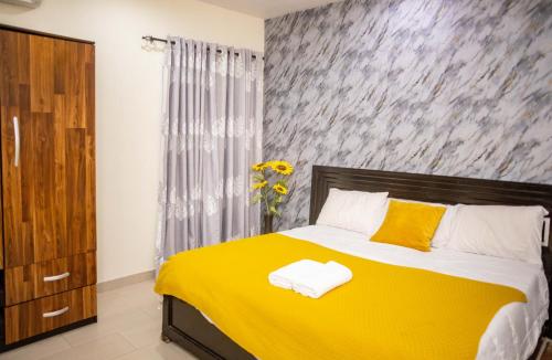 a bedroom with a bed with a yellow blanket at LEKKI SECRET MANSION 'n' SWIMMING POOl in Aja