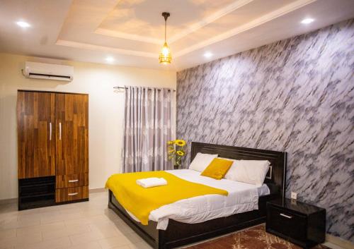 a bedroom with a bed and a stone wall at LEKKI SECRET MANSION 'n' SWIMMING POOl in Aja