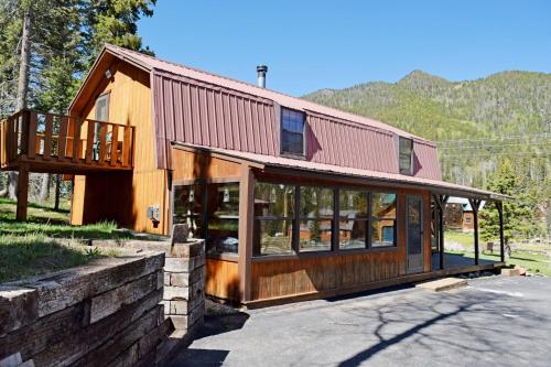 a house with a red roof and glass windows at Roberts Trappers Lodge - Pet Friendly - WiFi- Trailer Parking - Garage Access - Washer - Dryer - Great Views in Red River