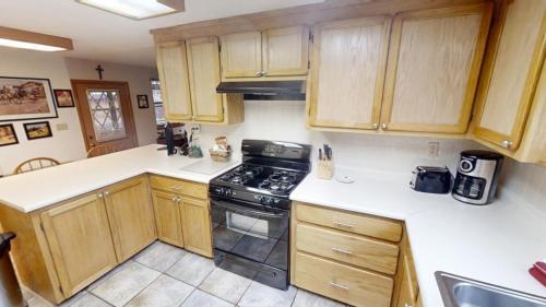 a kitchen with wooden cabinets and a stove top oven at Roberts Trappers Lodge - Pet Friendly - WiFi- Trailer Parking - Garage Access - Washer - Dryer - Great Views in Red River