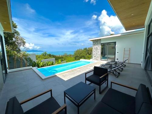 a patio with a pool and chairs and a house at Baan Saint-Tropez Seaview Villa Ko Samui Private Villa in Bophut 