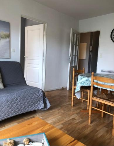 un salon avec un lit et une table dans l'établissement sainte cecile, à Sainte-Cécile-Plage