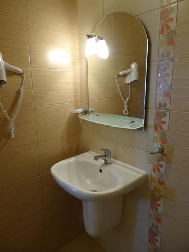 a bathroom with a sink and a mirror at Guesthouse Kamelia in Ahtopol