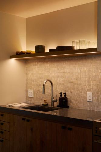a kitchen with a sink and a tiled wall at Sand Castle in Imperial Beach