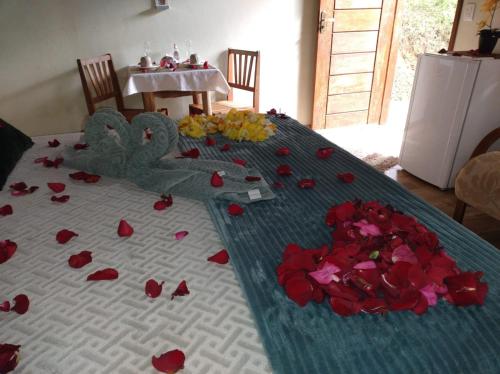 a table with red roses and hearts on it at Chalé dois irmãos in Visconde De Maua