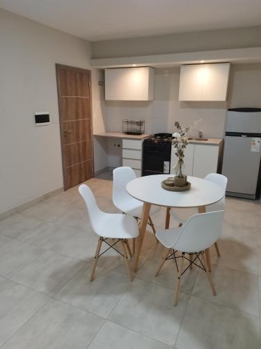 eine Küche mit einem weißen Tisch und weißen Stühlen in der Unterkunft Departamento en Barrio Sur in San Miguel de Tucumán