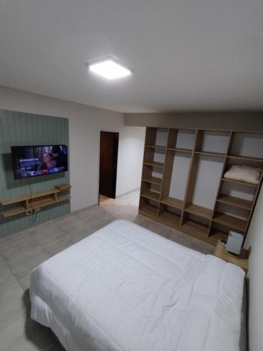 ein Schlafzimmer mit einem Bett und einem Flachbildfernseher in der Unterkunft Departamento en Barrio Sur in San Miguel de Tucumán