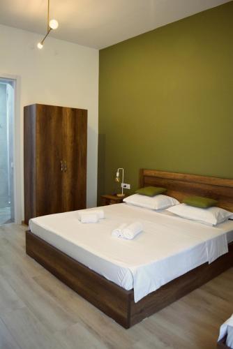 a bedroom with a large bed with two towels on it at Hotel Tabernei in Tbilisi City