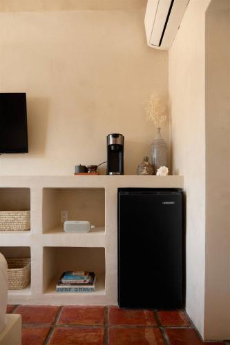 a living room with a tv and a black refrigerator at Sand Castle in Imperial Beach