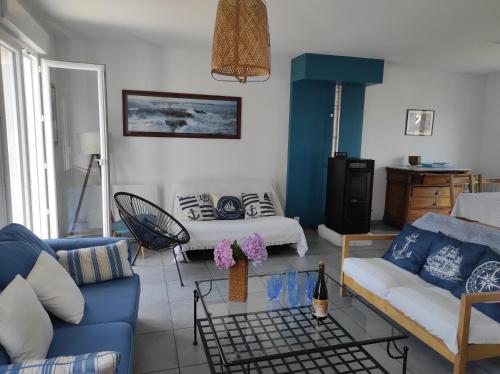- un salon avec un canapé bleu et un lit dans l'établissement Au Phare Breton - Arzon - Port du Crouesty, à Arzon