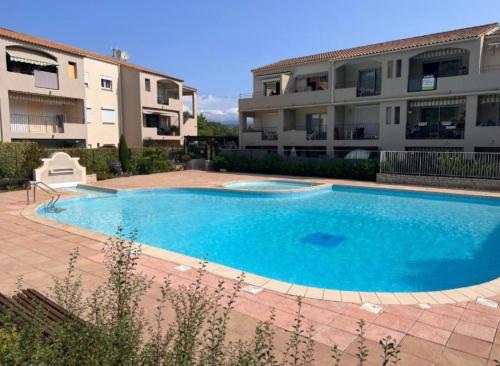 une grande piscine bleue devant un immeuble dans l'établissement Escapade aux vignes d'azur, au Beausset
