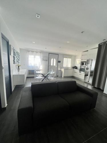 un salon avec un canapé et une cuisine dans l'établissement La Maisonnette Palavasienne, à Palavas-les-Flots