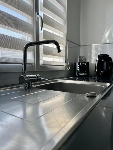 un comptoir de cuisine avec un évier et une fenêtre dans l'établissement La Maisonnette Palavasienne, à Palavas-les-Flots