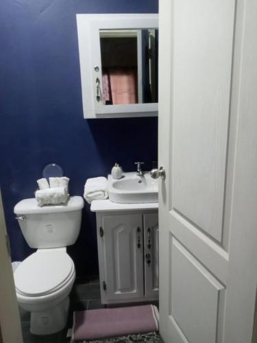 ein Badezimmer mit einer weißen Toilette und einem Waschbecken in der Unterkunft urban oasis in San Pedro Sula