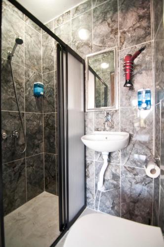 a bathroom with a shower and a sink at Terrace PEHLİVANLAR Hotel in Istanbul