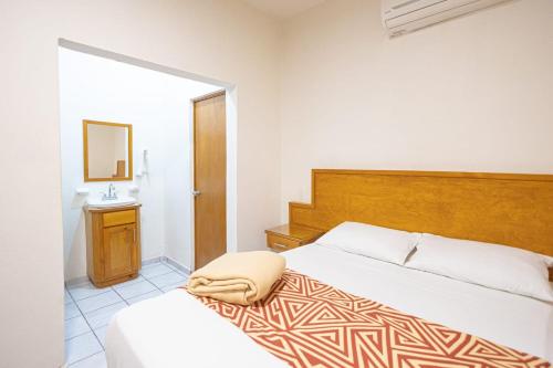 a bedroom with a bed and a mirror and a sink at Hotel Salvatierra in La Paz