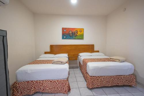 a room with three beds in a room at Hotel Salvatierra in La Paz