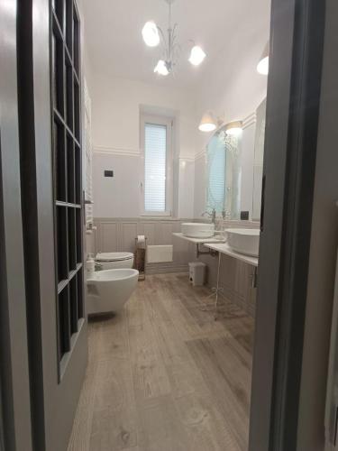 a white bathroom with two sinks and two toilets at Relais Tiaré Bed and Breakfast in Bacoli