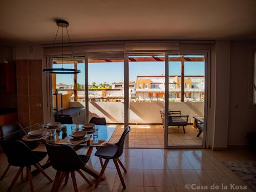 een eetkamer met een tafel en stoelen en een balkon bij Casa de la Kosa in San Miguel de Abona