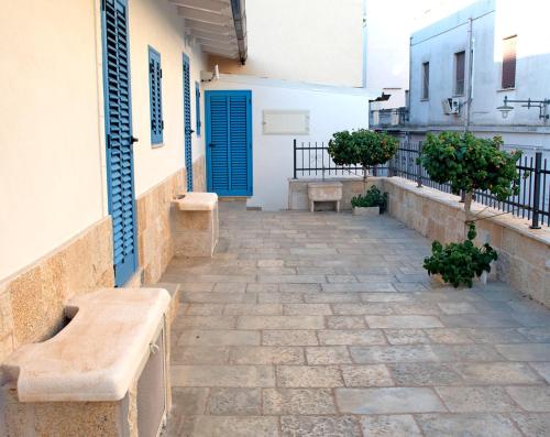a patio with benches and a blue door on a building at Le Casette in Brindisi