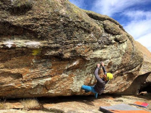 a person is climbing on a large rock at Casa rural Domínguez in Navalosa