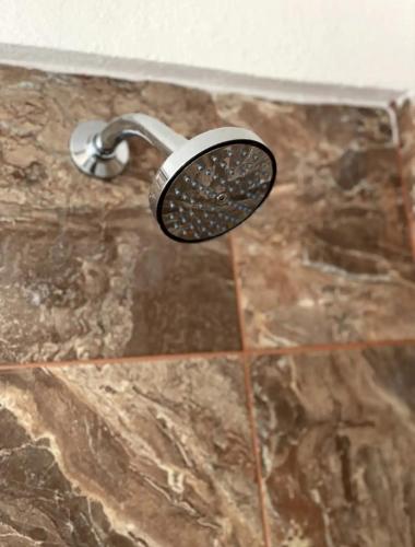 a shower with a shower head on a marble floor at Cabo Lofts in Cabo San Lucas