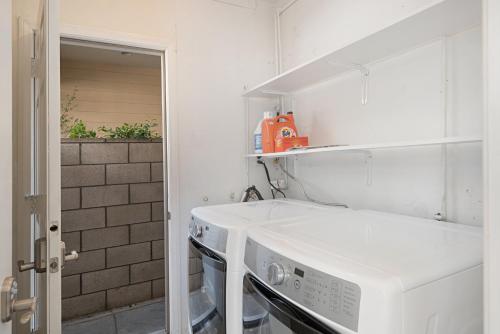 a white kitchen with a stove and a microwave at 118 Emerald Ave A & B in Newport Beach