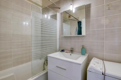 une salle de bain avec un lavabo, des toilettes et un miroir dans l'établissement T3 avec garage - proche Port & Plage, à Toulon
