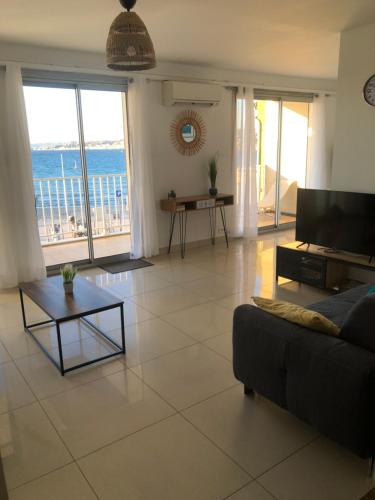un salon avec un canapé et une vue sur l'océan dans l'établissement Perle marine pointe rouge, à Marseille