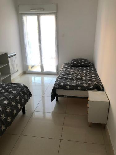 une petite chambre avec un lit et une fenêtre dans l'établissement Perle marine pointe rouge, à Marseille