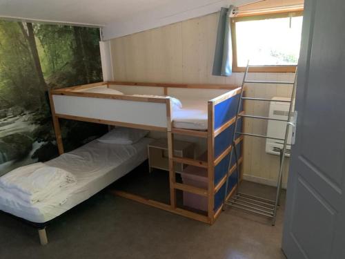 une chambre avec deux lits superposés et une fenêtre dans l'établissement Gîte la Zénitude, à Saint-Antonin