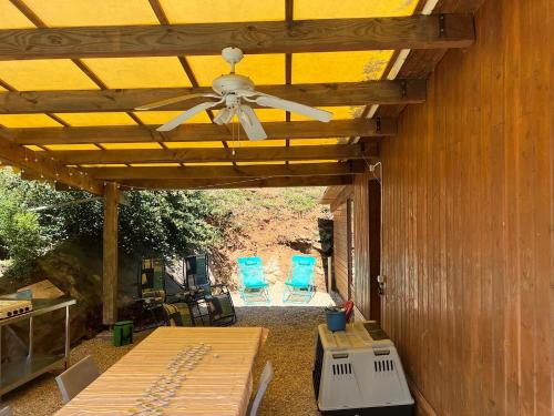 un patio avec un ventilateur de plafond et deux chaises bleues dans l'établissement Gîte la Zénitude, à Saint-Antonin