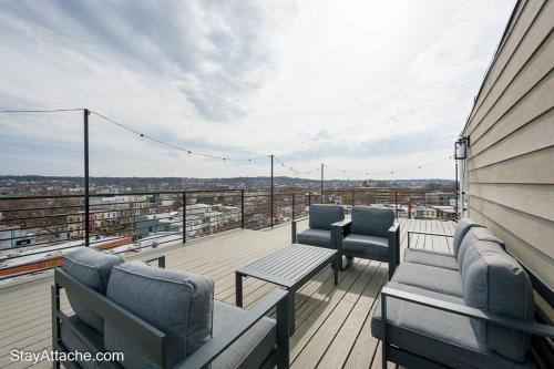 a balcony with chairs and tables on a building at LUX 3BR Apartment in DC with Rooftop in Washington, D.C.