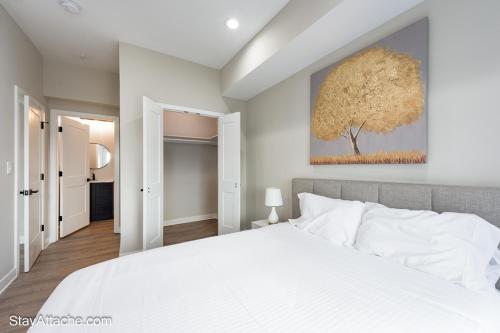 a bedroom with a white bed and a tree painting on the wall at LUX 3BR Apartment in DC with Rooftop in Washington, D.C.