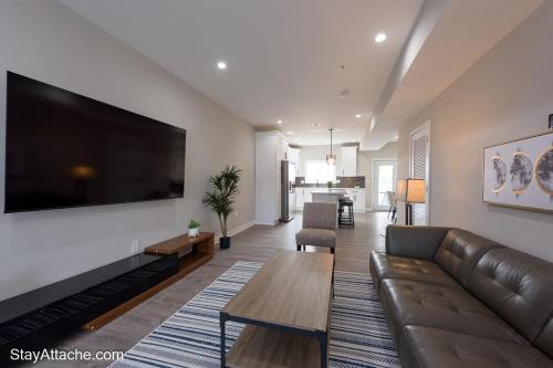 a living room with a couch and a large flat screen tv at LUX 3BR Apartment in DC with Rooftop in Washington, D.C.