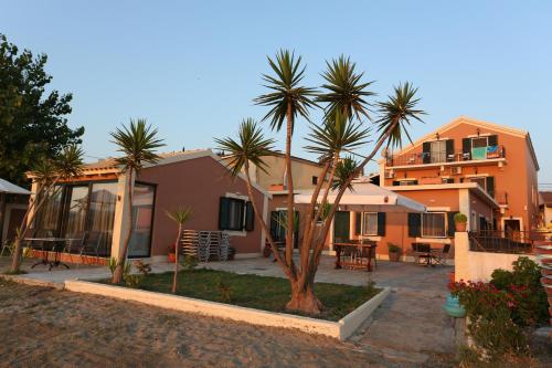 a house with palm trees in front of it at Electra Apartments in Sidari