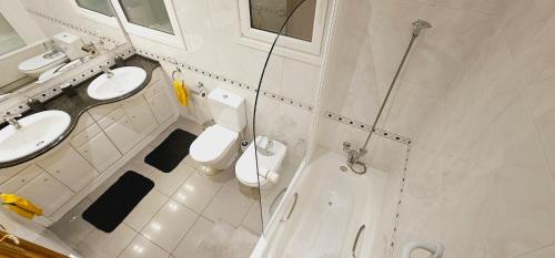 a bathroom with two sinks and a shower and two toilets at Apartamento exclusivo junto Sagrada Familia Barcelona in Barcelona