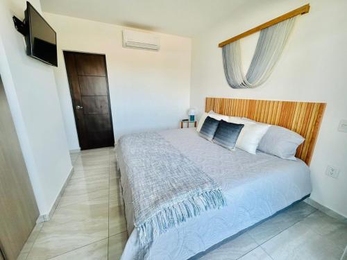a bedroom with a bed and a flat screen tv at moderno con alberca cerca de la playa by G P S rentas in Mazatlán