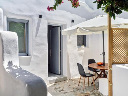 een patio met een tafel en een parasol bij Paros Iconic Apartments in Kampos Paros