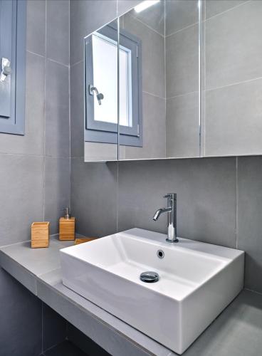 a bathroom with a white sink and a mirror at Paros Iconic Apartments in Kampos Paros
