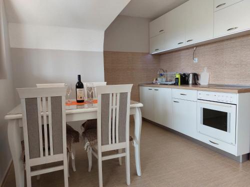 una cucina con un tavolo e due sedie con una bottiglia di vino di Zabljak Durmitor view a Žabljak
