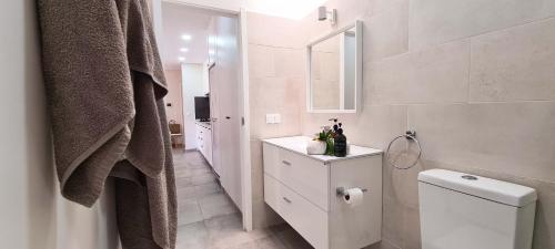 a bathroom with a toilet and a sink and a mirror at Papaya Apartments Sal Island in Santa Maria
