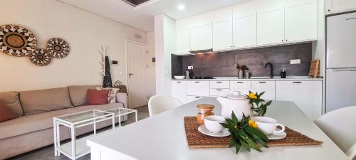 a kitchen and living room with a table and a couch at Papaya Apartments Sal Island in Santa Maria