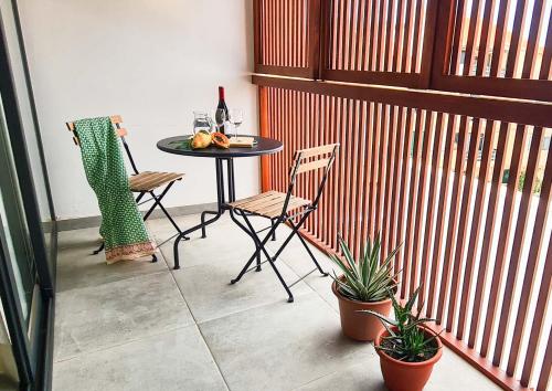 a patio with a table and two chairs and a bottle of wine at Papaya Apartments Sal Island in Santa Maria