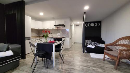 a kitchen and a living room with a table and chairs at Apartamenty Parkowe nr 7 in Kwidzyn