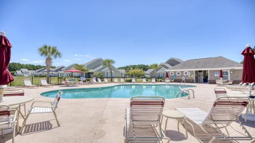 a swimming pool with lounge chairs and a table at 511 Heron Bay in Briarwood