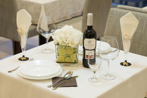 a table with a bottle of wine and glasses at Garni Hotel Central Lux in Kragujevac