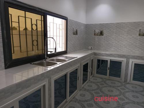 Un baño con lavabo y ventana. en Villa 3 patios, en Somone